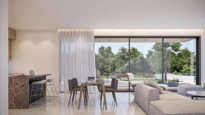 2-Lana-Villa-5-Kitchen_diningjpg - Sovereign Estates Sovereign Estates Bright open plan living area with glass sliding doors to a garden dining table for six grey sofa and marble kitchen island with stools 2026 Bright open plan living area with glass sliding doors to a garden dining table for six grey sofa and marble kitchen island with stools