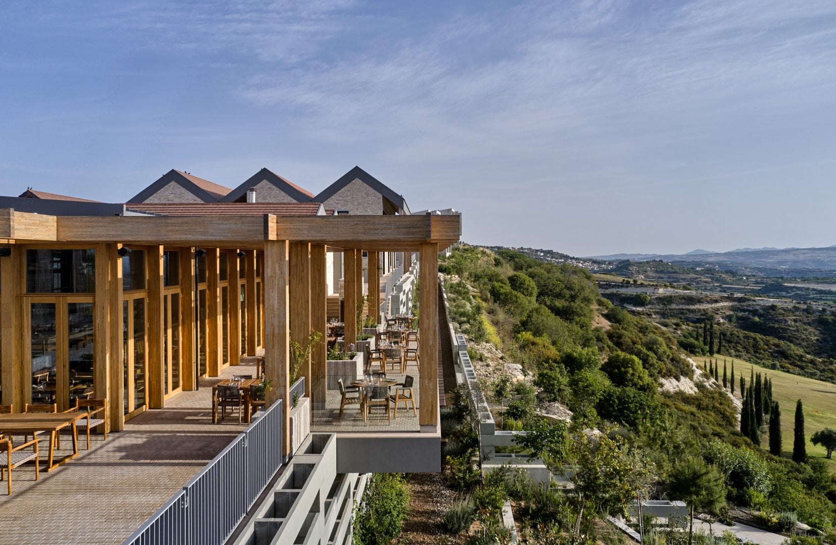DJI_0483-1656x1080jpg - Sovereign Estates Sovereign Estates Outdoor dining terrace with wooden posts and tables overlooking a valley and hills in the distance 2026 Outdoor dining terrace with wooden posts and tables overlooking a valley and hills in the distance