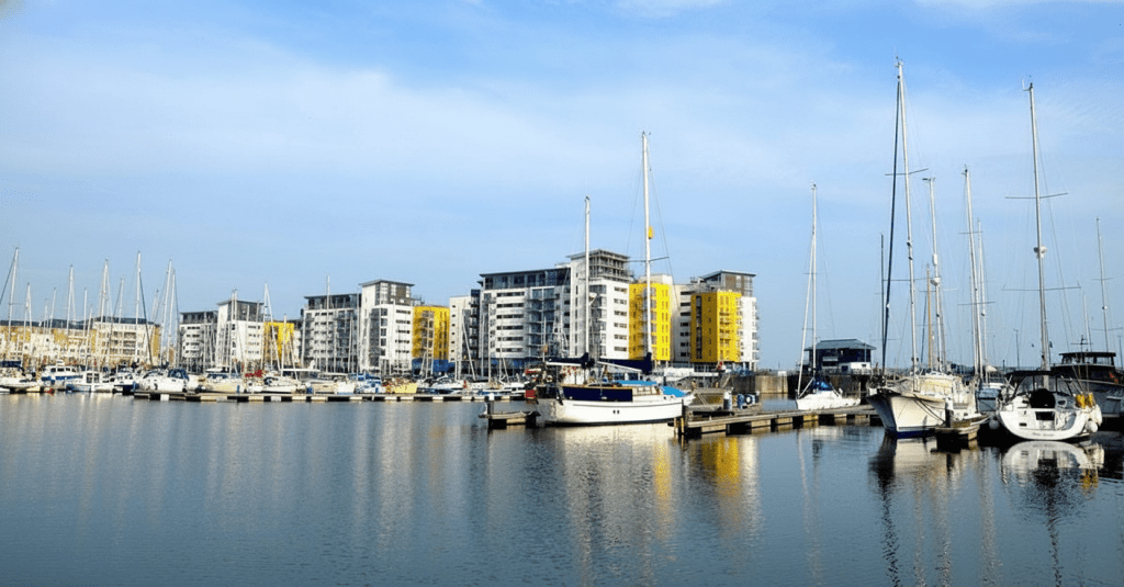 01d36b734ccd40149b14cdef6ce63e7f - Sovereign Estates Sovereign Estates Marina with sailboats docked along piers and modern white buildings with yellow accents along the waterfront 2026 Marina with sailboats docked along piers and modern white buildings with yellow accents along the waterfront