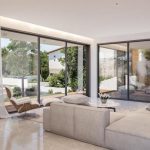 Sovereign Estates   Spacious modern living room with a beige sectional sofa floor to ceiling glass walls and a view of a patio and garden 2026 Spacious modern living room with a beige sectional sofa floor to ceiling glass walls and a view of a patio and garden