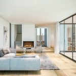 Sovereign Estates   Bright contemporary living room with a gas fireplace light gray sofa and floor to ceiling glass walls 2026 Bright contemporary living room with a gas fireplace light gray sofa and floor to ceiling glass walls