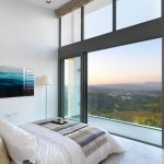 Sovereign Estates   Bright modern bedroom with floor to ceiling glass doors and a balcony overlooking a hillside sunset view 2026 Bright modern bedroom with floor to ceiling glass doors and a balcony overlooking a hillside sunset view
