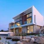 Sovereign Estates   Modern two story house with white and stone exterior large glass walls and rocky desert landscaping 2026 Modern two story house with white and stone exterior large glass walls and rocky desert landscaping
