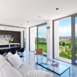 Sovereign Estates   Open plan living area with floor to ceiling windows showing a countryside view marble floor beige sofa and glass coffee table near the kitchen 2026 Open plan living area with floor to ceiling windows showing a countryside view marble floor beige sofa and glass coffee table near the kitchen