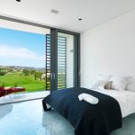 Sovereign Estates   Bright modern bedroom with a sliding glass door to a balcony overlooking a green landscape  2026 Bright modern bedroom with a sliding glass door to a balcony overlooking a green landscape
