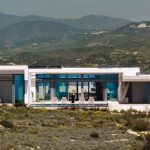 Sovereign Estates   Modern white villa with large glass walls outdoor seating and a mountain range backdrop a person stands on the deck 2026 Modern white villa with large glass walls outdoor seating and a mountain range backdrop a person stands on the deck