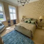IMG_21_11_largejpg - Sovereign Estates Sovereign Estates Elegant bedroom with cream wallpaper ornate blue bed and wicker striped chairs under two large windows with blinds 2026 Elegant bedroom with cream wallpaper ornate blue bed and wicker striped chairs under two large windows with blinds