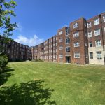 IMG_21_15_largejpg - Sovereign Estates Sovereign Estates Red brick apartment complex with a central grassy courtyard and clear blue sky above 2026 Red brick apartment complex with a central grassy courtyard and clear blue sky above