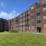 IMG_21_17_largejpg - Sovereign Estates Sovereign Estates Brick apartment buildings enclose a green lawn courtyard on a sunny day with a blue sky above 2026 Brick apartment buildings enclose a green lawn courtyard on a sunny day with a blue sky above