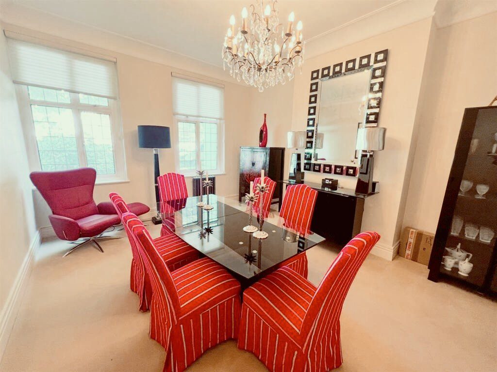 IMG_21_27_largejpg - Sovereign Estates Sovereign Estates Dining room with a glass dining table surrounded by six red striped chairs a crystal chandelier and a black sideboard with a square framed mirror above it 2026 Dining room with a glass dining table surrounded by six red striped chairs a crystal chandelier and a black sideboard with a square framed mirror above it