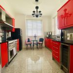 IMG_21_2_largejpg - Sovereign Estates Sovereign Estates Bright kitchen with glossy red cabinets stainless appliances and a small round dining table by a window 2026 Bright kitchen with glossy red cabinets stainless appliances and a small round dining table by a window