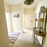 Sovereign Estates   Hallway with a decorative console table and mirror two lamps and a beige rug in a bright entryway 2026 Hallway with a decorative console table and mirror two lamps and a beige rug in a bright entryway