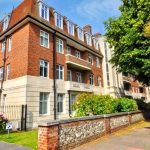 Sovereign Estates   Red brick apartment building with a beige lower façade gated entrance and lush flowering garden on a sunny day 2026 Red brick apartment building with a beige lower façade gated entrance and lush flowering garden on a sunny day