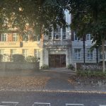 Sovereign Estates   Entrance to Pearl Court a brick and stone apartment building with glass doors framed by green trees and a low stone wall nearby 2026 Entrance to Pearl Court a brick and stone apartment building with glass doors framed by green trees and a low stone wall nearby