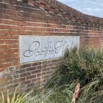 Sovereign Estates   Stone plaque with cursive text mounted on a red brick wall reading 'Pacific Heights' with tall ornamental grasses in the foreground 2026 Stone plaque with cursive text mounted on a red brick wall reading 'Pacific Heights' with tall ornamental grasses in the foreground