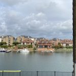 Sovereign Estates   Waterfront scene with boats docked along a calm river and brick houses across the water under a cloudy sky viewed from a railing lined foreground 2026 Waterfront scene with boats docked along a calm river and brick houses across the water under a cloudy sky viewed from a railing lined foreground