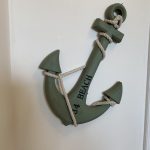 Sovereign Estates   Decorative green anchor wall hanging with rope wrapped around it and the text '54 BEACH' along the shaft mounted indoors 2026 Decorative green anchor wall hanging with rope wrapped around it and the text '54 BEACH' along the shaft mounted indoors