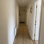 Sovereign Estates   Narrow hallway in a home with white walls light wood floor and doors along the right a lifebuoy hangs on the wall 2026 Narrow hallway in a home with white walls light wood floor and doors along the right a lifebuoy hangs on the wall