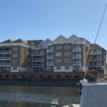 Sovereign Estates   Brick apartment complex along a marina with balconies beside a calm canal and moored sailboats on the right 2026 Brick apartment complex along a marina with balconies beside a calm canal and moored sailboats on the right