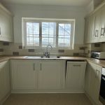 Sovereign Estates   White Ushaped kitchen with shaker cabinets wood countertops a double sink under a window and a toaster on the right counter 2026 White Ushaped kitchen with shaker cabinets wood countertops a double sink under a window and a toaster on the right counter