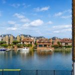 Sovereign Estates   Waterfront scene with a calm canal moored sailboat and motorboat and a row of brick and timber houses along the shore under a blue sky 2026 Waterfront scene with a calm canal moored sailboat and motorboat and a row of brick and timber houses along the shore under a blue sky