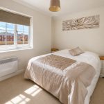 Sovereign Estates   A neatly made double bed with a beige quilt and a small pillow flanked by white nightstands in a bright bedroom 2026 A neatly made double bed with a beige quilt and a small pillow flanked by white nightstands in a bright bedroom