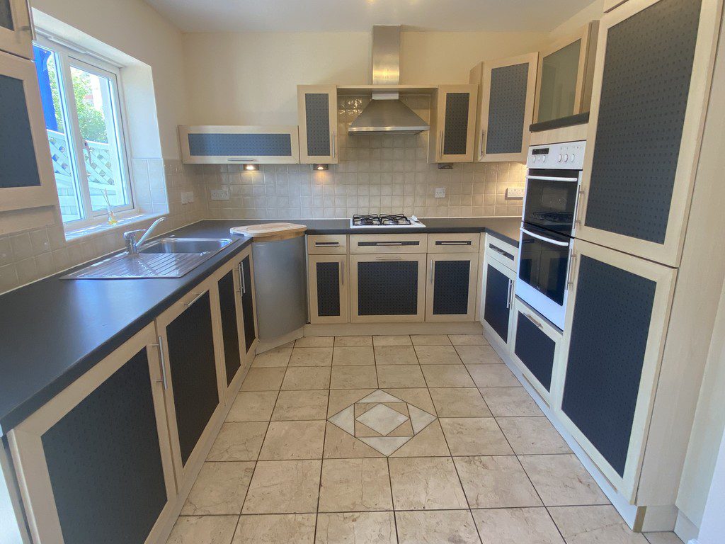 IMG_23_33_largejpg - Sovereign Estates Sovereign Estates L shaped cream kitchen with dark panel cabinets stainless steel appliances and a window above the sink on the left 2026 L shaped cream kitchen with dark panel cabinets stainless steel appliances and a window above the sink on the left