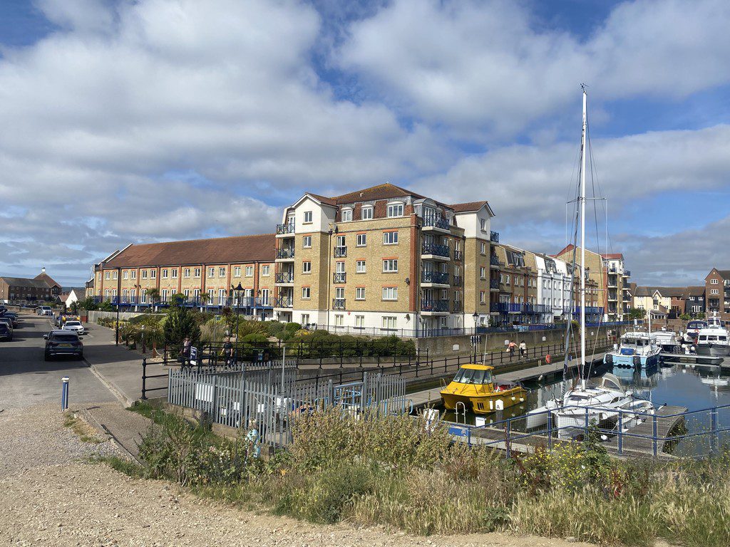 IMG_23_3_largejpg - Sovereign Estates Sovereign Estates Harbor side with several brick apartment buildings along a canal and boats docked by a walkway under a cloudy blue sky 2026 Harbor side with several brick apartment buildings along a canal and boats docked by a walkway under a cloudy blue sky