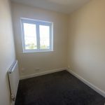 IMG_23_52_largejpg - Sovereign Estates Sovereign Estates Small empty bedroom with a window beige walls dark carpet and a wall mounted radiator 2026 Small empty bedroom with a window beige walls dark carpet and a wall mounted radiator