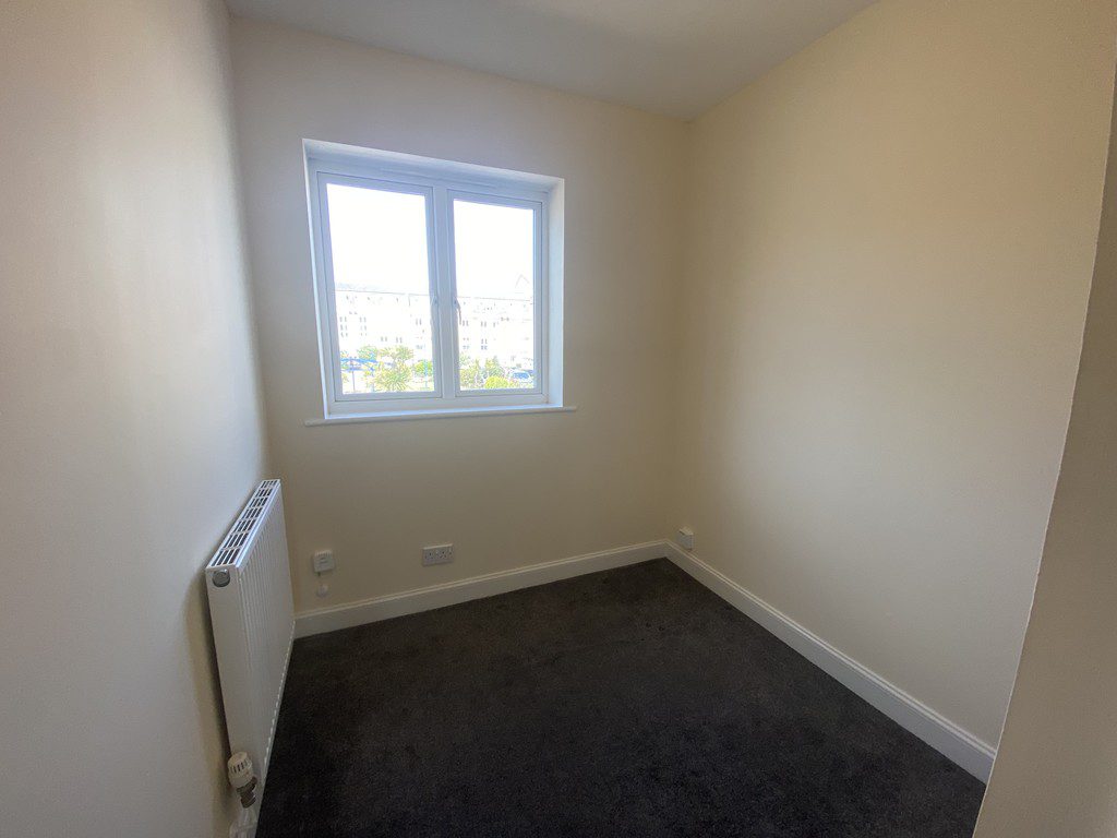 IMG_23_52_largejpg - Sovereign Estates Sovereign Estates Small empty bedroom with a window beige walls dark carpet and a wall mounted radiator 2026 Small empty bedroom with a window beige walls dark carpet and a wall mounted radiator