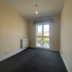 IMG_23_56_largejpg - Sovereign Estates Sovereign Estates Small empty room with cream walls dark carpet and a radiator along the left wall a large window with a balcony railing lets in daylight showing buildings outside 2026 Small empty room with cream walls dark carpet and a radiator along the left wall a large window with a balcony railing lets in daylight showing buildings outside