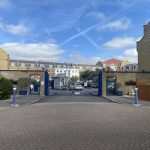 IMG_23_77_largejpg - Sovereign Estates Sovereign Estates Gated entrance to a residential complex with blue gates and brick walls with cars parked inside under a clear blue sky 2026 Gated entrance to a residential complex with blue gates and brick walls with cars parked inside under a clear blue sky