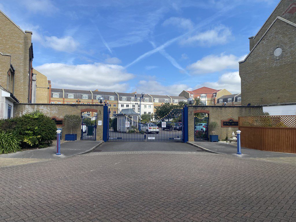 IMG_23_77_largejpg - Sovereign Estates Sovereign Estates Gated entrance to a residential complex with blue gates and brick walls with cars parked inside under a clear blue sky 2026 Gated entrance to a residential complex with blue gates and brick walls with cars parked inside under a clear blue sky