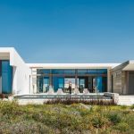 Sovereign Estates   Modern white contemporary house with large glass doors outdoor seating and a low pool under a clear blue sky 2026 Modern white contemporary house with large glass doors outdoor seating and a low pool under a clear blue sky
