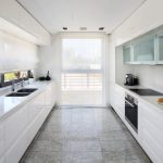 Sovereign Estates   Bright white galley kitchen with glossy cabinets long countertops and a double sink under a large window on the left 2026 Bright white galley kitchen with glossy cabinets long countertops and a double sink under a large window on the left