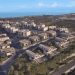 Sovereign Estates   Aerial view of a hillside residential development with modern beige townhouses and winding roads overlooking the blue sea in the distance 2026 Aerial view of a hillside residential development with modern beige townhouses and winding roads overlooking the blue sea in the distance