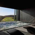 Sovereign Estates   Indoor spa pool with a glass wall view of a sunlit golf course outside dark loungers and towels in the foreground 2026 Indoor spa pool with a glass wall view of a sunlit golf course outside dark loungers and towels in the foreground