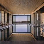Sovereign Estates   Indoor pool area in a modern spa stone pillars wooden ceiling lounge chairs along the sides and a large window view 2026 Indoor pool area in a modern spa stone pillars wooden ceiling lounge chairs along the sides and a large window view