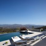 Sovereign Estates   Infinity pool on a terrace with white lounge chairs towels and a scenic hilly landscape under a clear blue sky 2026 Infinity pool on a terrace with white lounge chairs towels and a scenic hilly landscape under a clear blue sky