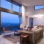 Sovereign Estates   Spacious modern living room with floor to ceiling windows overlooking a mountainous landscape cream sofas and a marble floor 2026 Spacious modern living room with floor to ceiling windows overlooking a mountainous landscape cream sofas and a marble floor