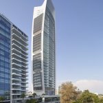 Sovereign Estates   Tall curved glass skyscraper with a white façade beside a modern glass building on a tree lined street under a clear blue sky 2026 Tall curved glass skyscraper with a white façade beside a modern glass building on a tree lined street under a clear blue sky