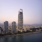 Sovereign Estates   Skyline of a coastal city at dusk featuring a tall curved skyscraper labeled ONE with a beach and water in the foreground 2026 Skyline of a coastal city at dusk featuring a tall curved skyscraper labeled ONE with a beach and water in the foreground