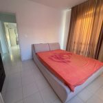 Sovereign Estates   Beige upholstered bed with an orange duvet in a bright minimalist bedroom and brown sheer curtains by a large window 2026 Beige upholstered bed with an orange duvet in a bright minimalist bedroom and brown sheer curtains by a large window