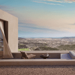 Sovereign Estates   Modern terrace of a contemporary home with glass doors beige curtains a lounge chair round table with a hat and a white sofa overlooking a valley and sea at sunset 2026 Modern terrace of a contemporary home with glass doors beige curtains a lounge chair round table with a hat and a white sofa overlooking a valley and sea at sunset