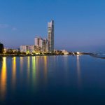 Sovereign Estates   Coastal cityscape at blue hour with a tall skyscraper and illuminated buildings reflecting on the calm water 2026 Coastal cityscape at blue hour with a tall skyscraper and illuminated buildings reflecting on the calm water