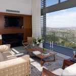 Sovereign Estates   Bright living room with cream sofas a wooden fireplace wall and floortoceiling windows overlooking a valley view 2026 Bright living room with cream sofas a wooden fireplace wall and floortoceiling windows overlooking a valley view