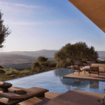 Sovereign Estates   Infinity pool overlooking a valley with hills lounge chairs and outdoor seating on a sunlit terrace 2026 Infinity pool overlooking a valley with hills lounge chairs and outdoor seating on a sunlit terrace