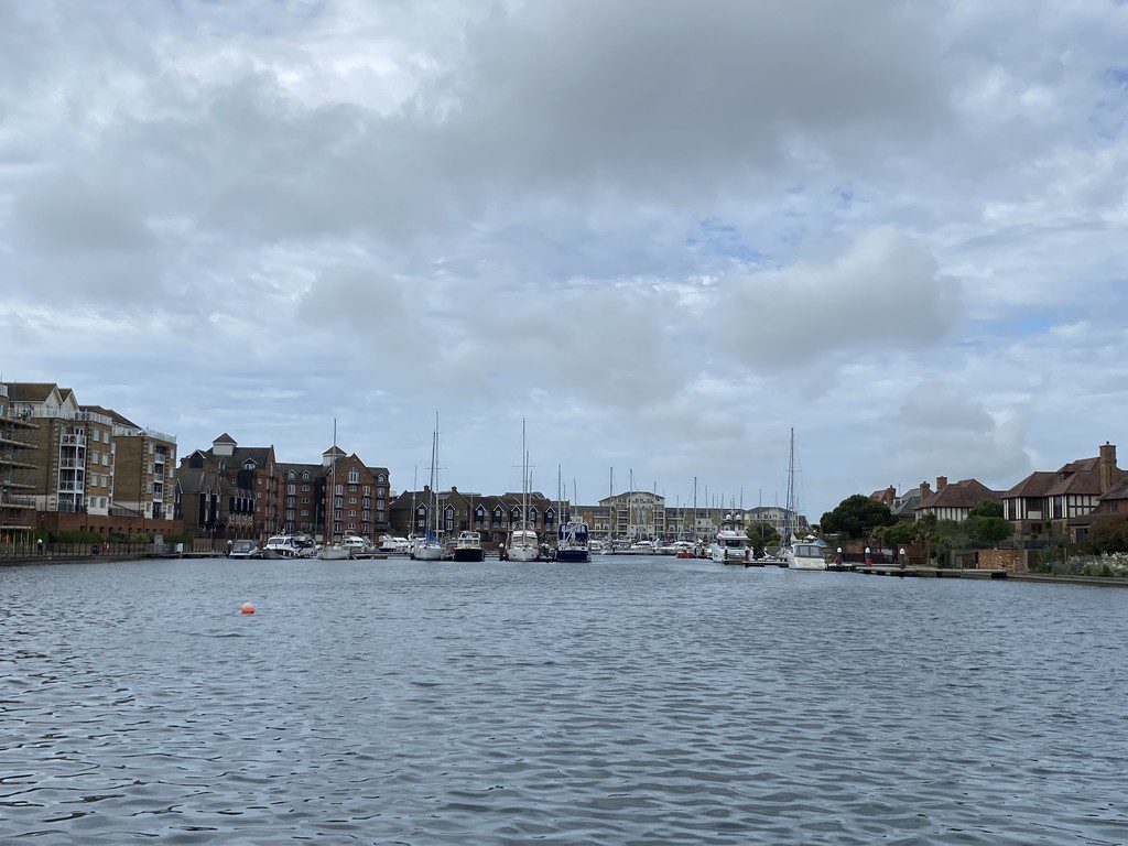 IMG_25_19_largejpg - Sovereign Estates Sovereign Estates A marina with moored boats and sailboats along a calm waterway brick buildings lining the shore under a cloudy sky 2026 A marina with moored boats and sailboats along a calm waterway brick buildings lining the shore under a cloudy sky