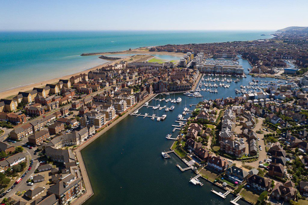 IMG_25_1_largejpg - Sovereign Estates Sovereign Estates Aerial view of a coastal town with a marina boats docked along canals and a sandy beach to the left 2026 Aerial view of a coastal town with a marina boats docked along canals and a sandy beach to the left