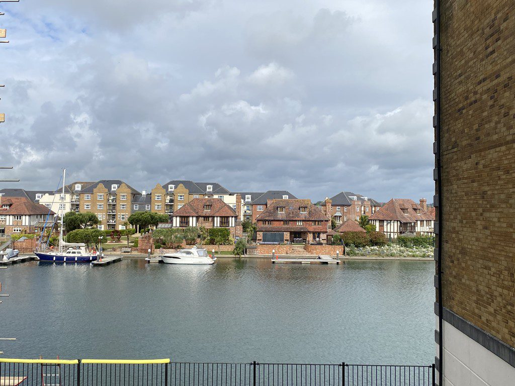 IMG_25_21_largejpg - Sovereign Estates Sovereign Estates Waterfront with moored boats and a row of brick houses along the river under a cloudy sky 2026 Waterfront with moored boats and a row of brick houses along the river under a cloudy sky
